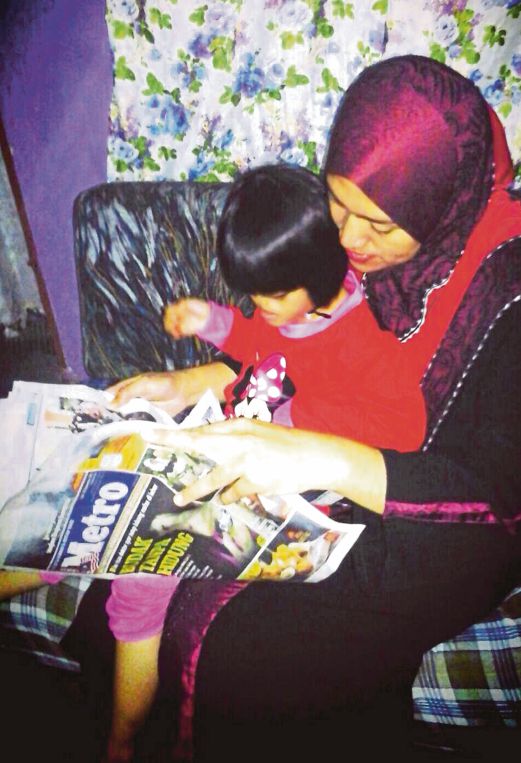 DAYANA dan ibunya melihat keratan akhbar Harian Metro di Kempas.