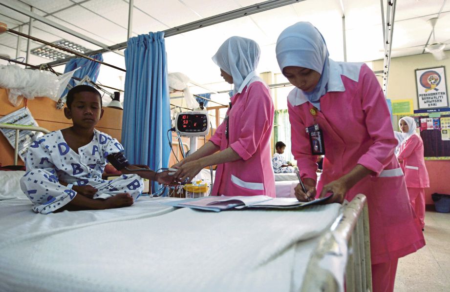 KAKITANGAN perubatan memeriksa seorang kanak-kanak orang asli yang dijangkiti malaria di Hospital Gerik.