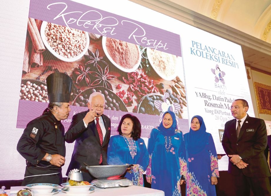 NAJIB  merasa menu yang disediakan   Rosmah  sempena pelancaran laman web baru BAKTI  dan Buku Koleksi Resipi Bakti.