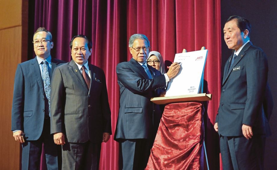 MUSTAPA (tiga dari kiri) menandatangani  buku Laporan MITI 2015 sebagai simbolik majlis pelancaran. 