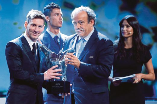 PRESIDEN UEFA  Michel Platini (kanan) menyerahkan trofi Pemain Terbaik Eropah kepada Messi.