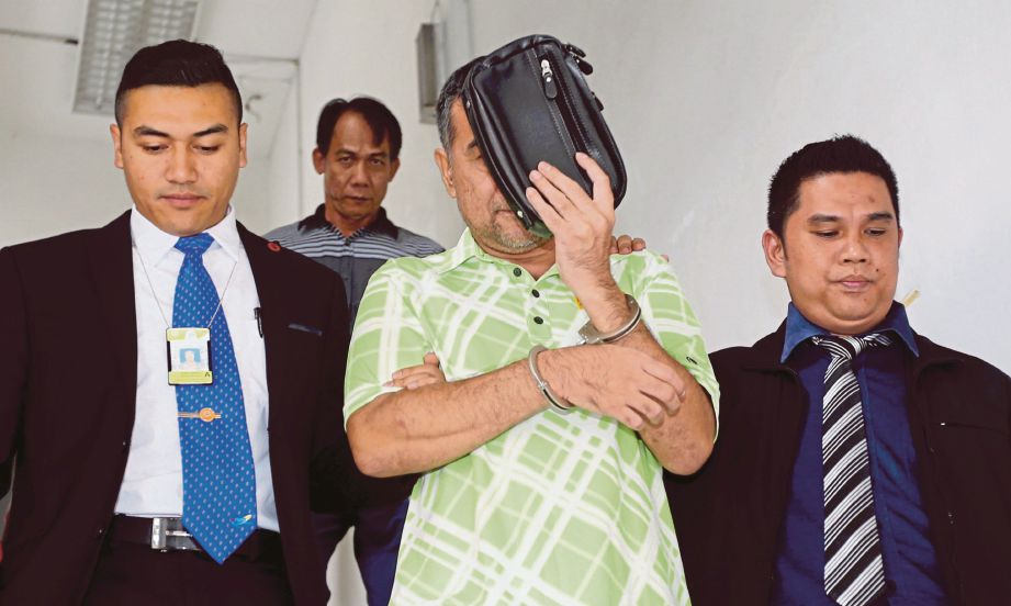  Awang (tengah) dibawa anggota SPRM keluar dari Mahkamah Sesyen Kota Kinabalu.