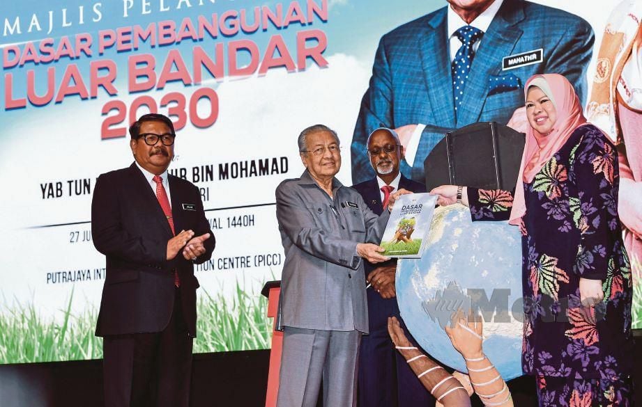 DR Mahathir menerima buku Dasar Pembangunan Luar Bandar 2030 daripada Rina, semalam. 