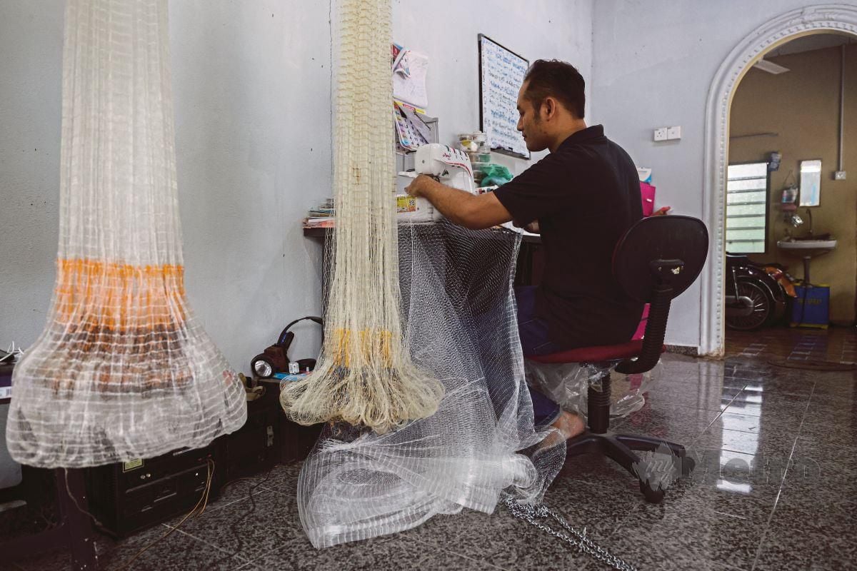 MUHAMAD Amzar  menggunakan mesin jahit yang   diinovasi untuk menghasilkan jala di kedainya di Kampung Changkat Dain, Sungai Bakap.