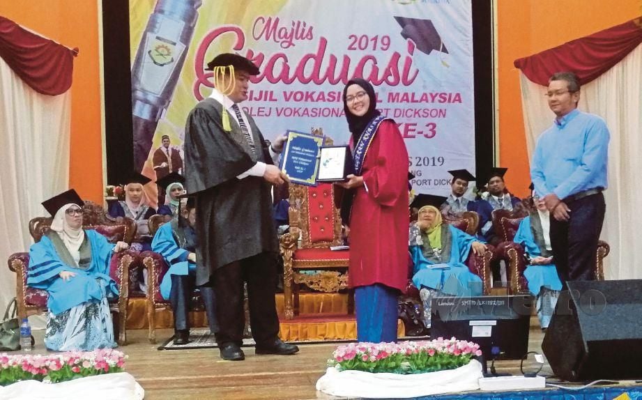 SANUSI  (kiri) menyampaikan Anugerah Khas Pengarah, Pelajar Terbaik Sijil Vokasional Malaysia KOHOT 2017 kepada Nur Syazwani pada Majlis Graduasi Kolej Vokasional Port Dickson, Port Dickson.
