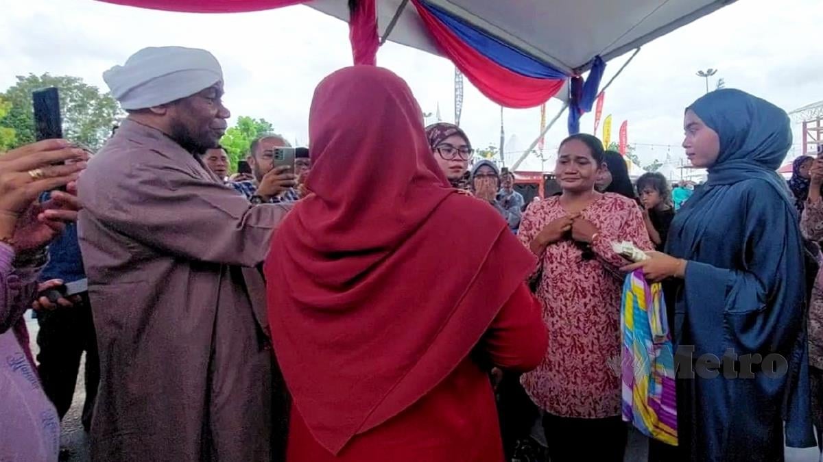 NORHAYATI (dua kanan) melafaz kalimah syahadah di KIAM 2023 yang disaksikan dua anak perempuannya. FOTO Ihsan Pembaca.