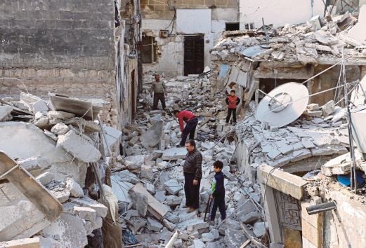 PENDUDUK Syria mencari barang yang mungkin masih boleh dipakai di celah runtuhan bangunan di kawasan kejiranan Kalasa di Aleppo, utara Syria, semalam.  Aleppo terbahagi kepada dua antara penyokong pemberontak di timur dan penyokong kerajaan di barat sejak perang saudara meletus pada 2012.