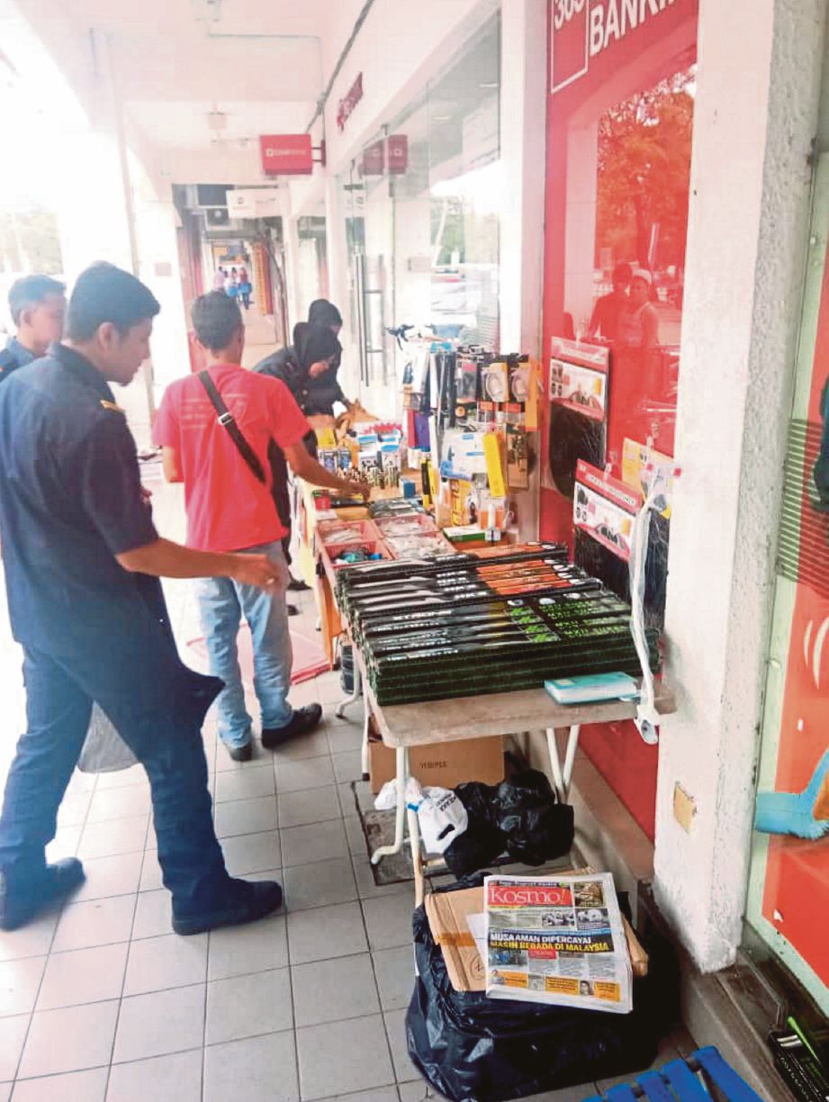   Anggota penguat kuasa  MPN menyita barangan yang dijual warga asing di Taman Semarak 2, Nilai. 
