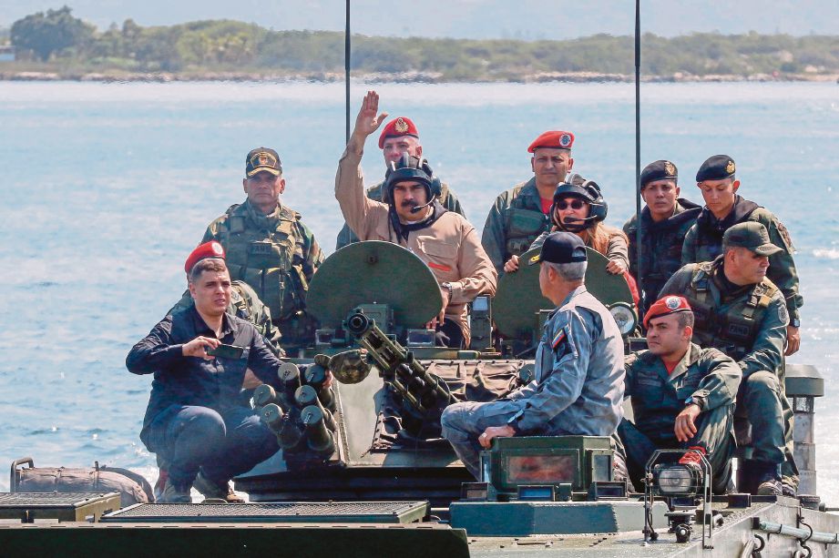PRESIDEN Venezuela, Nicolas Maduro (tengah) bersama isterinya, Cilia Flores (kanan) di atas bot amfibia ketika latihan ketenteraan di sebuah pangkalan tentera laut, semalam. - FOTO via AFP