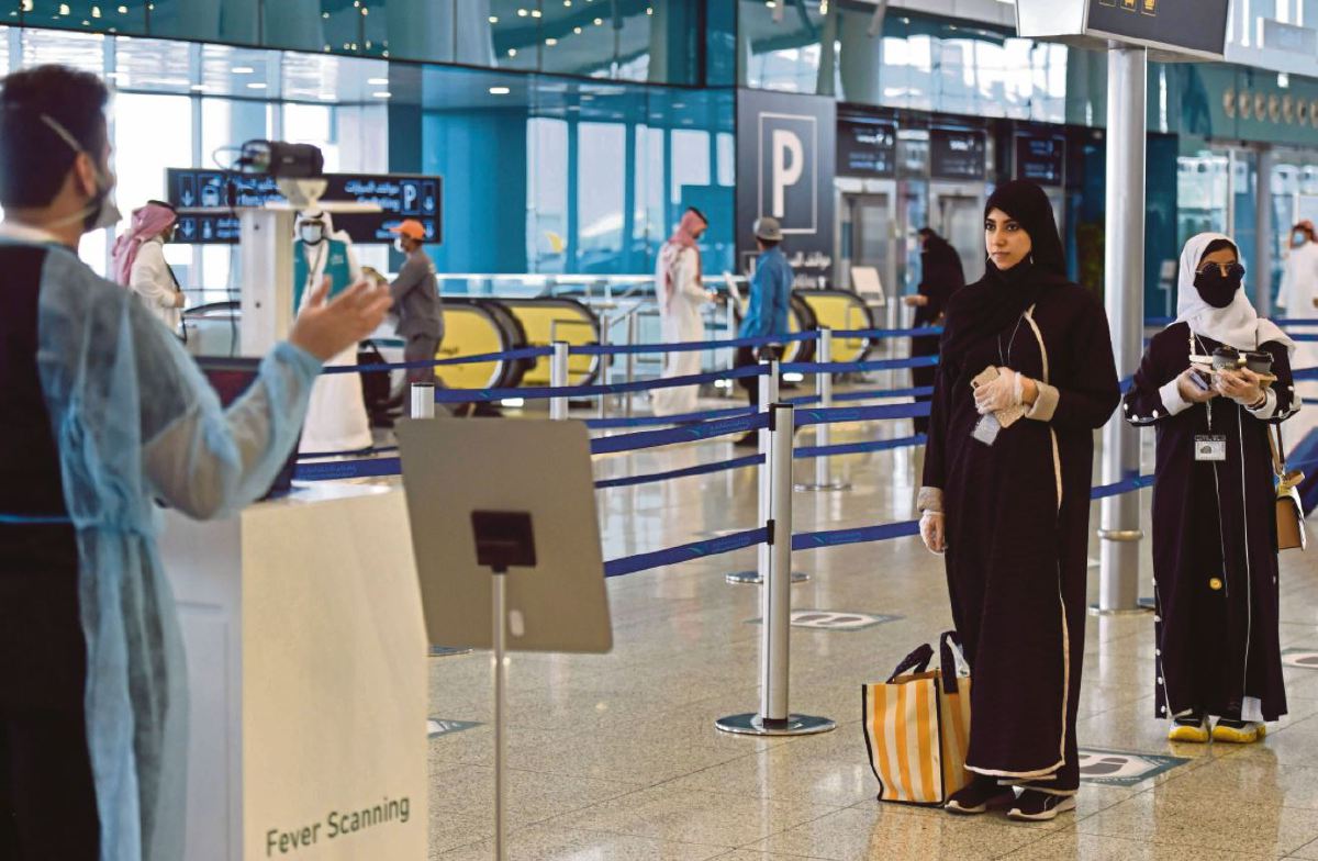 Gambar fail, penumpang memeriksa suhu badan di terminal lima Lapangan Terbang Antarabangsa King Fahad di Riyadh. FOTO AFP.