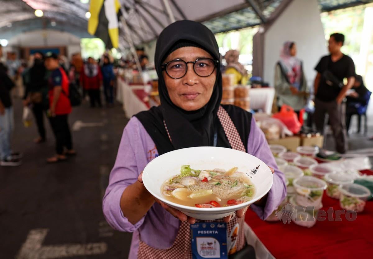 PENIAGA Laksa Kuale Umi Klasum Bakri, 56, menunjukkan laksa dijual di gerainya pada Pesta Laksa Kuale di Arena Kuala Kangsar hari ini. FOTO Bernama.