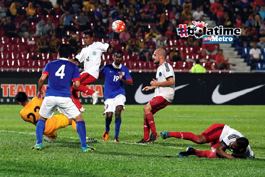 Penjaga gol Malaysia Mohd Izham Tarmizi (kiri) terjatuh ketika menyelamatkan gawang dari asakan pemain Timor Leste, Frangcyatma Alves (tiga dari kiri). - Foto HAIRUL ANUAR RAHIM