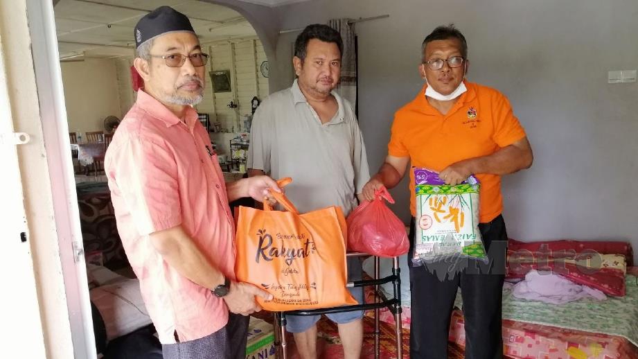 BAKRI menyampaikan sumbangan makanan kepada Azim Aziz (tengah) di rumahnya di Kampung Batu Serambai. FOTO Abnor Hamizam