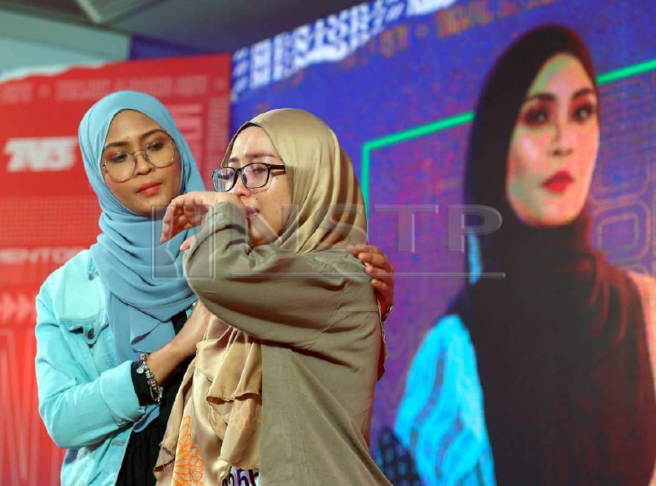 SITI Nordiana (kiri) menenangkan Jiyana Zardi dari Sabah yang menangis ketika menyampaikan lagu pada ujibakat Mentor 7. FOTO Khairul Azhar Ahmad