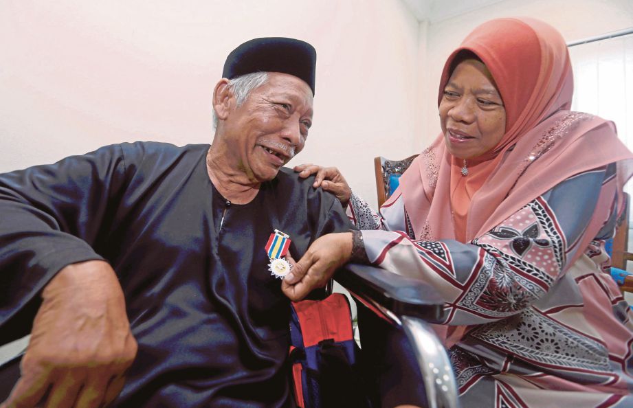 SANIMAN (kiri) menunjukkan pingat PJPN yang diterima kepada Hasnah pada Majlis Istiadat Penganugerahan PJPN Kontinjen Johor  di Dewan Dato’ Onn, IPK Johor.