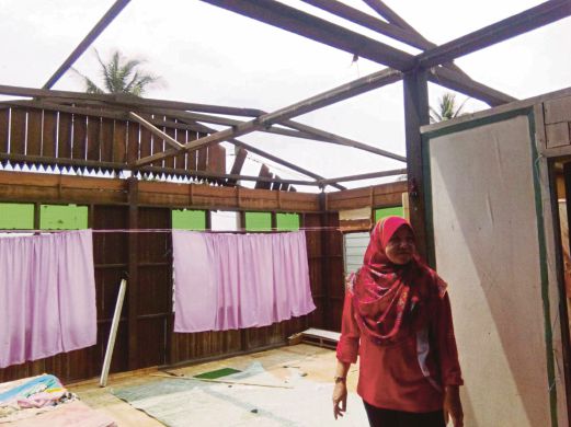 KEADAAN sebuah rumah dipukul ribut. Gambar kecil, Norasiah mendukung Nurul Auni Syazwan.