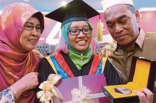 NUR Hazlizan (tengah) berkongsi kejayaan bersama ibu dan bapanya.