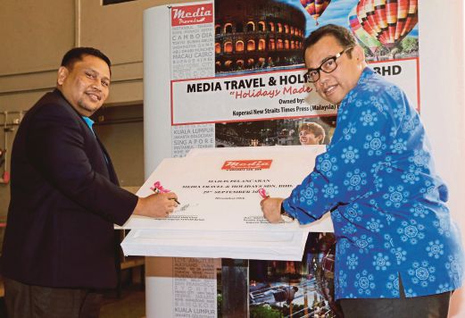 ABDUL Fattah (kanan) bersama Mohd Fadzil Abdul Ghani menandatangani plak perasmian pada Majlis Pelancaran Media Travel & Holidays Sdn Bhd di Balai Berita NSTP, Kuala Lumpur. 