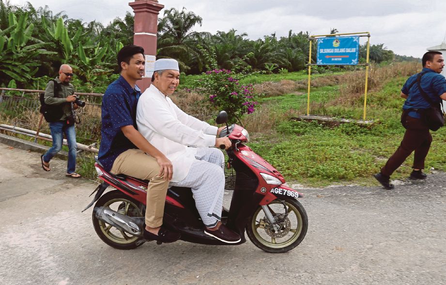 AHMAD Zahid  menunggang motosikal ke Masjid As Saadah selepas melawat Sekolah Kebangsaan Sungai Dulang Dalam, Sungai Sumun, semalam.