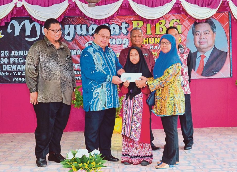 SHAMSULKAHAR menyampaikan sumbangan peralatan sekolah di SMK Yam Tuan Radin, semalam.