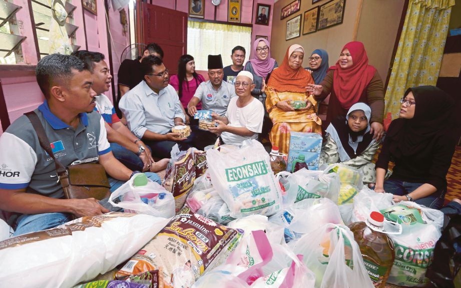 Dazar (tengah) menerima sumbangan  Econsave disampaikan Mas Imran (tiga dari kiri) dan wakil Kelab Media Johor di kediamannya, semalam.