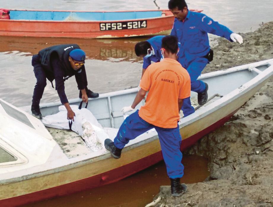 Anggota penyelamat mengangkat mayat Abang Kamal yang ditemui kira-kira lima batu nautika dari Kampung Penipah, Pulau Bruit, semalam.