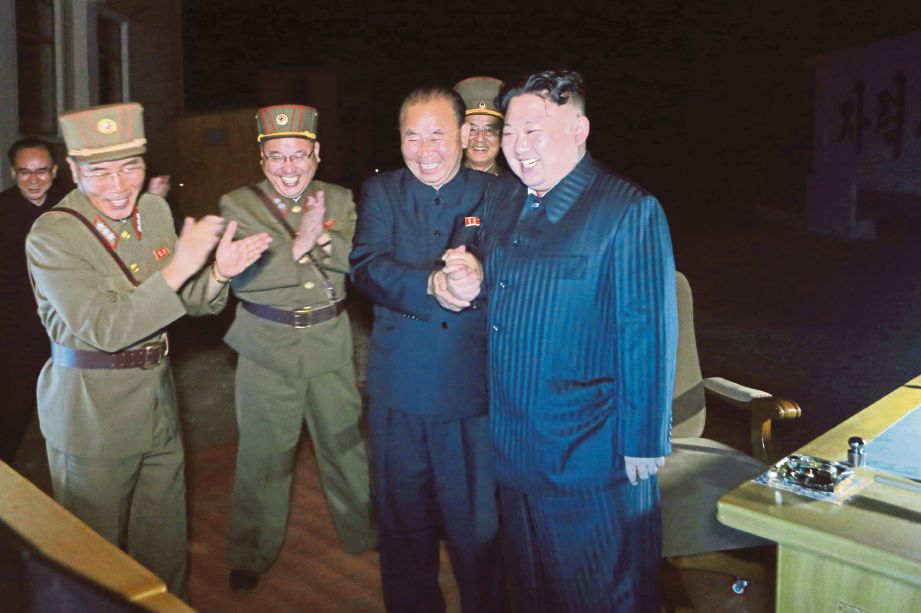 JONG-un (kanan) bersama pegawainya meraikan kejayaan ujian kedua peluru berpandu Hwasong-14 kelmarin. - EPA