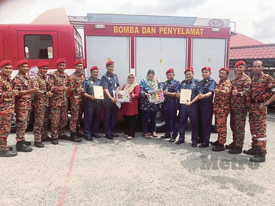 SUHAILY (tengah) menyampaikan sijil penghargaan dan kuih kepada anggota bomba. FOTO Ahmad Ismail