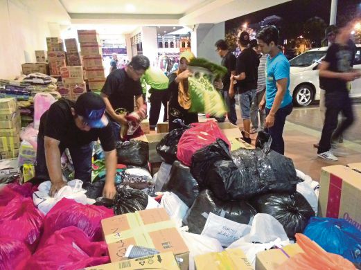  AHLI Kelab Ultras Malaya Taming Sari Melaka memasukkan barangan sumbangan orang ramai.