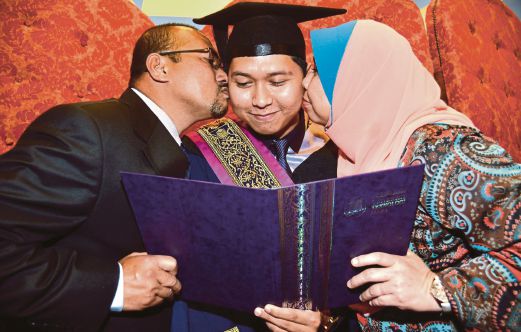 MUHAMAD Helmi  menerima ciuman tahniah daripada ibu bapa Datin Siti Halimah Bahaman dan Datuk Mohd Kamil Abd Aziz.