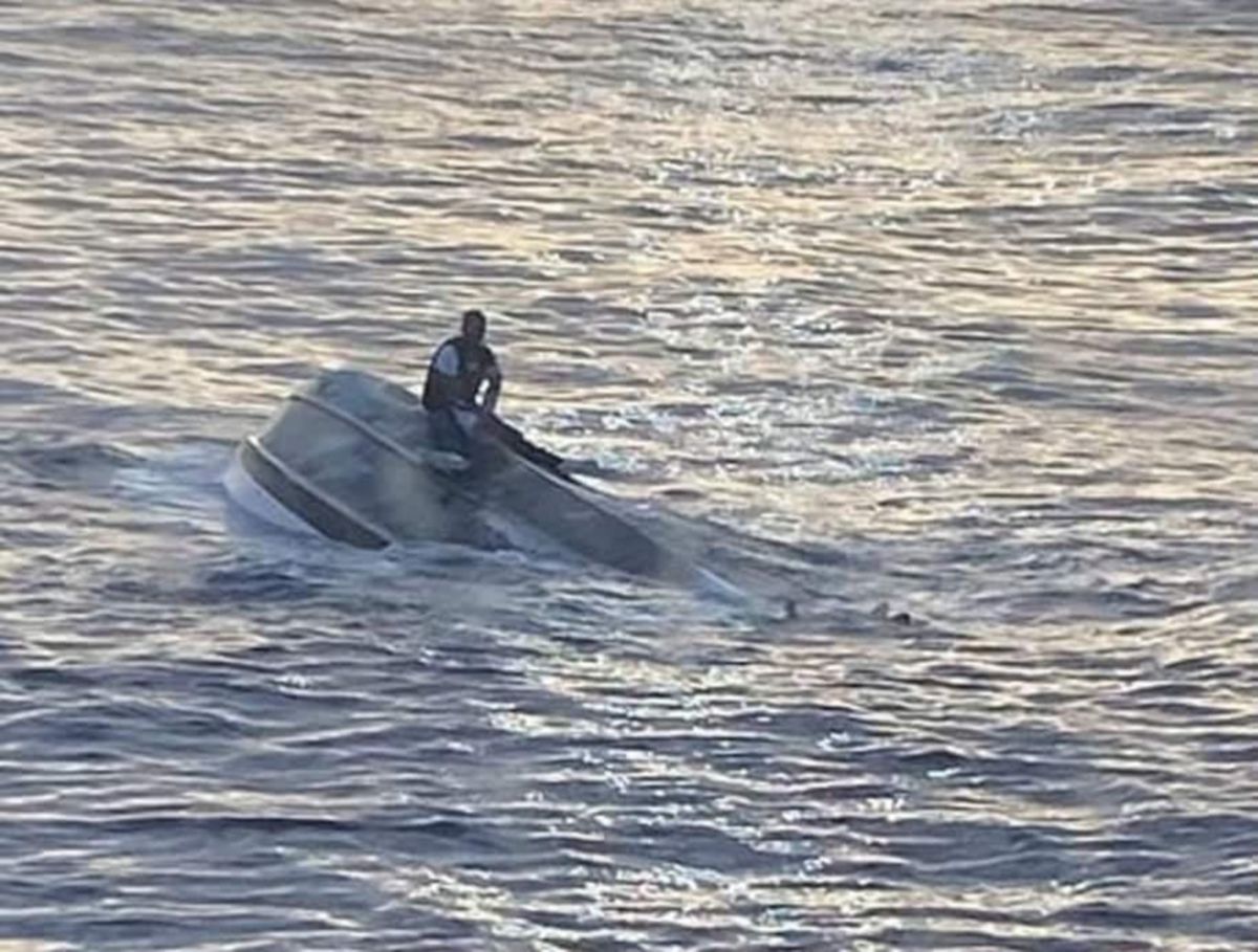 Imej seorang lelaki disahkan Juan Estaban di atas bot yang terbalik. FOTO Agensi.