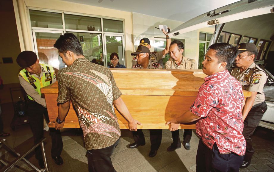 PETUGAS mengusung keranda pesalah warga Nigeria, Seck Osmanu yang tiba di sebuah rumah mayat di Jakarta, semalam. - AP