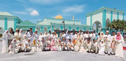 EMPAT puluh pasangan pengantin bergambar di depan masjid.