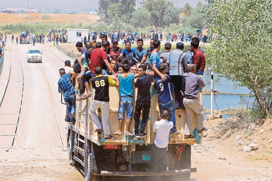 ORANG awam menaiki kenderaan tentera untuk pulang ke kediaman mereka di Mosul. - Reuters