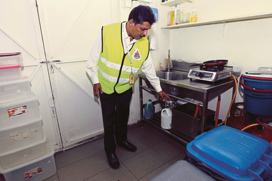   Penolong Pegawai Kesihatan dan Persekitaran DBKL, Pushpagaran Munusamy memeriksa persekitaran gerai makanan ketika operasi kesihatan dan kebersihan DBKL di sekitar Jalan Telawi, Bangsar.