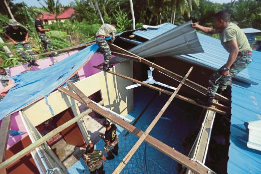  anggota tentera membaik pulih bumbung mangsa ribut di Kampung Teluk Rimba, semalam.