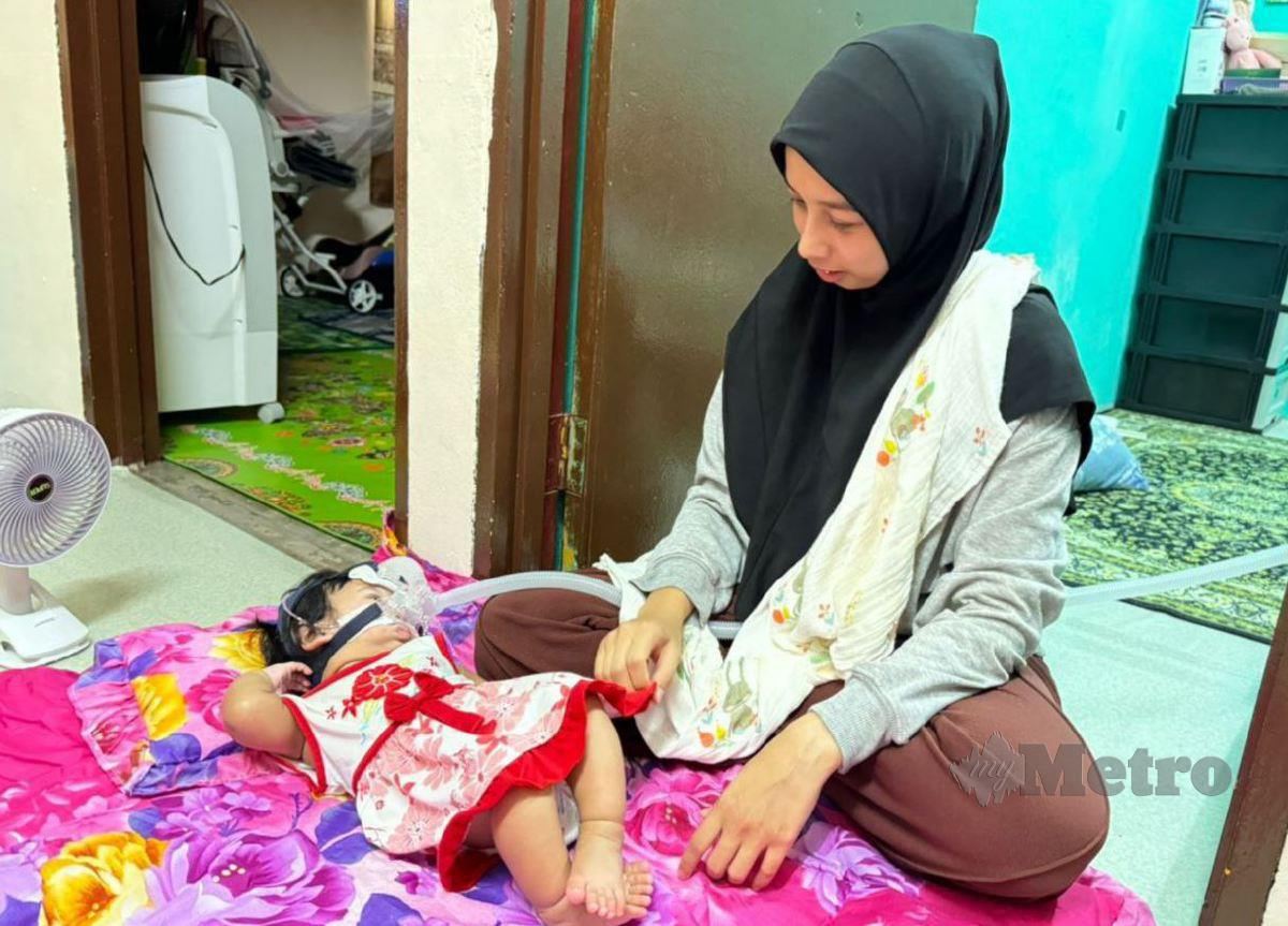 NUR Hasnadia melihat anaknya, Nur Afeeya Haura yang mengidap sindrom Pierre Robin dan sumbing lelangit sejak lahir. FOTO Noorazura Abdul Rahman.