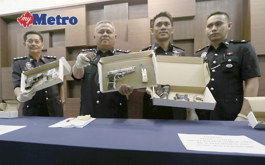TIMBALAN Ketua Polis Kedah, Datuk Abdul Jalil Hassan (tiga kanan) bersama pegawainya menunjukan dua pucuk pistol dan 49 butir peluru hidup yang dirampas. FOTO Sharul Hafiz Zam