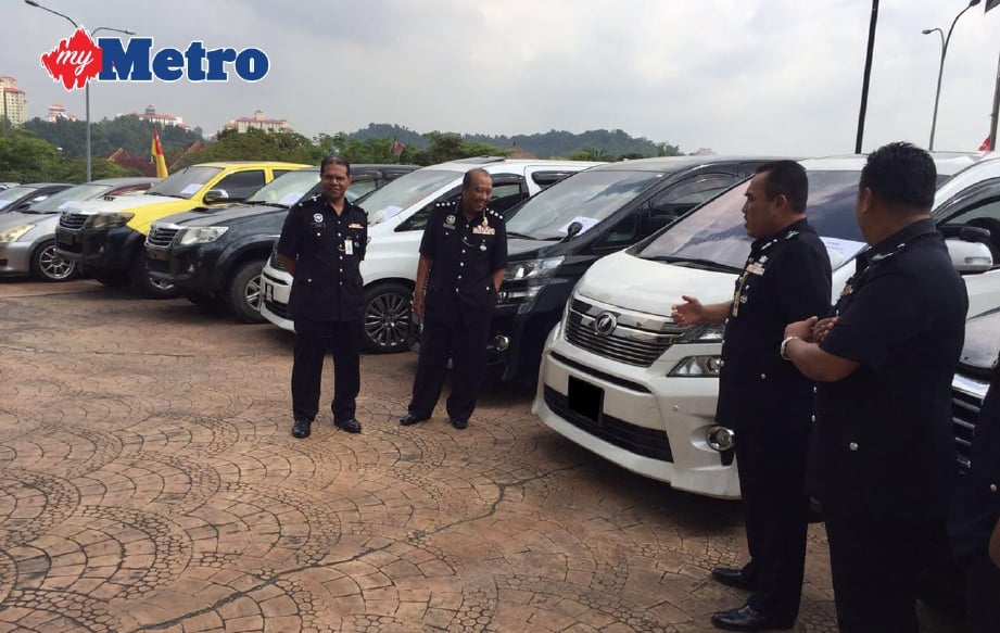 FADZIL (dua dari kanan) bersama Ketua Polis Daerah Serdang Asisten Komisioner Megat Mohd Aminuddin Megat Alias (tiga dari kanan) melihat sebahagian kenderaan yang dirampas. FOTO Mohd Fadly Samsudin