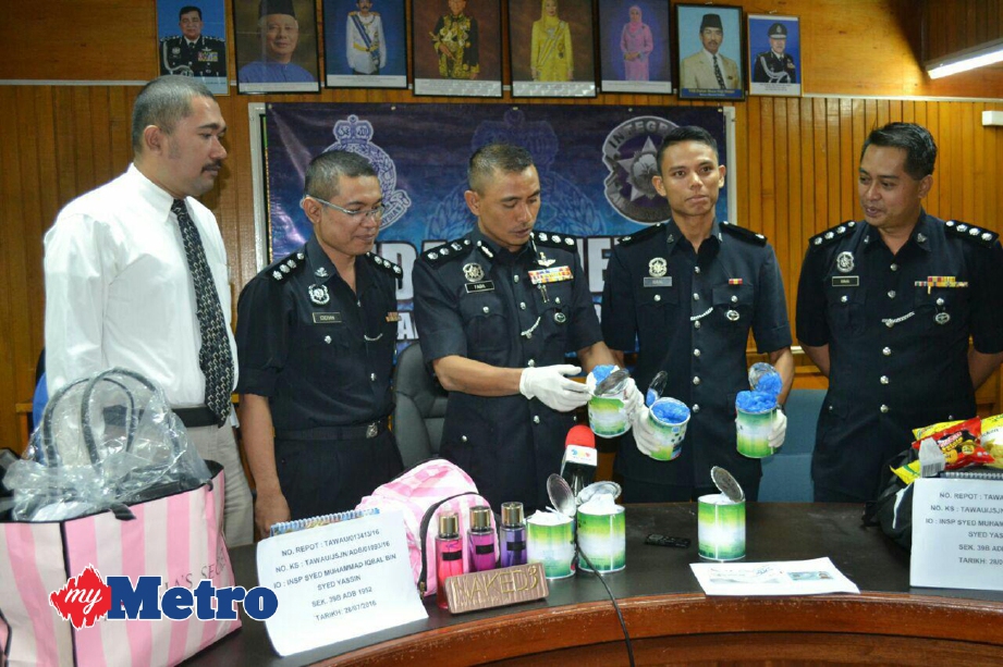 FADIL (tengah) memeriksa dadah yang dirampas dalam sidang media di IPD Tawau. FOTO ihsan PDRM