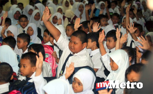 Murid tahun satu menggangkat tangan di perhimpunan pada hari pertama persekolahan di SK Nong Chik, Johor Bahru. FOTO Zulkarnain Ahmad Tajuddin