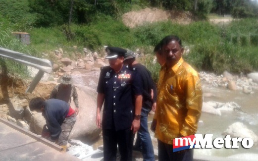 ZAINAL Abidin meninjau keadaan jambatan runtuh di Sungai Ulu Tenom. FOTO ihsan Polis