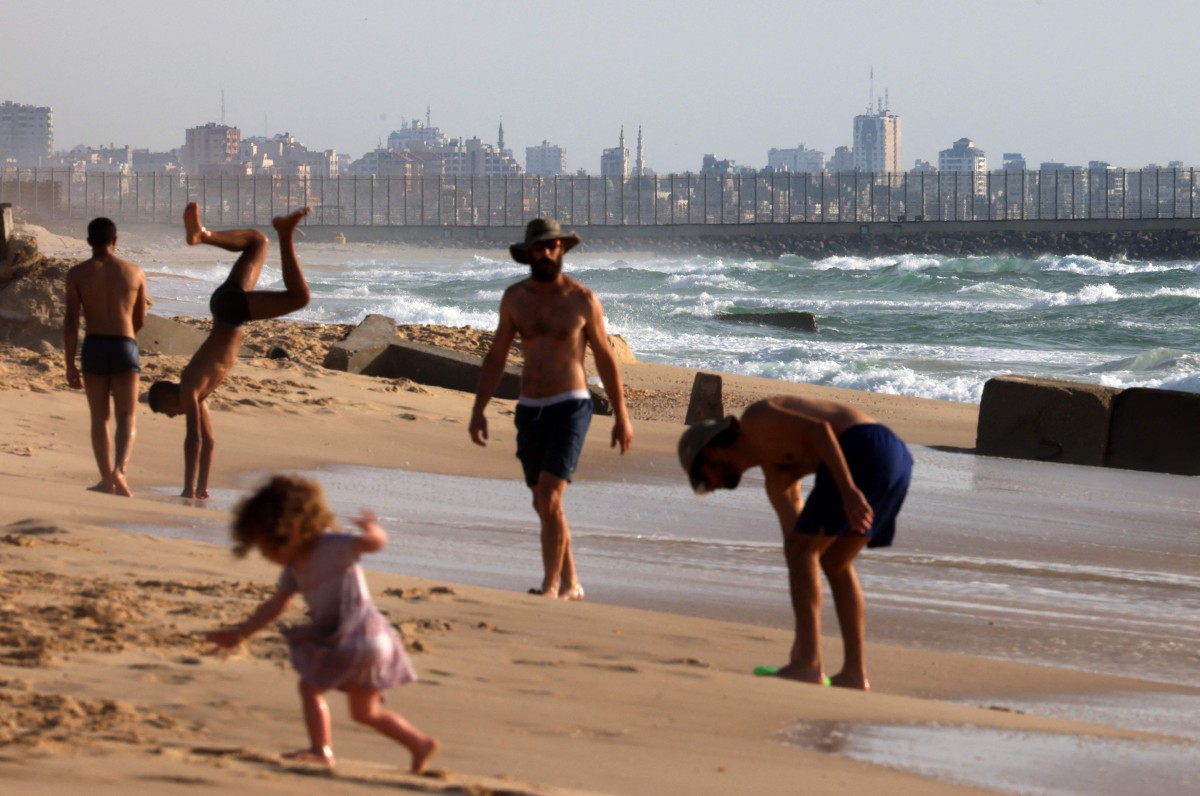 PENDUDUK Israel beriadah di pantai berhampiran dengan Semenanjung Gaza. FOTO AFP 
