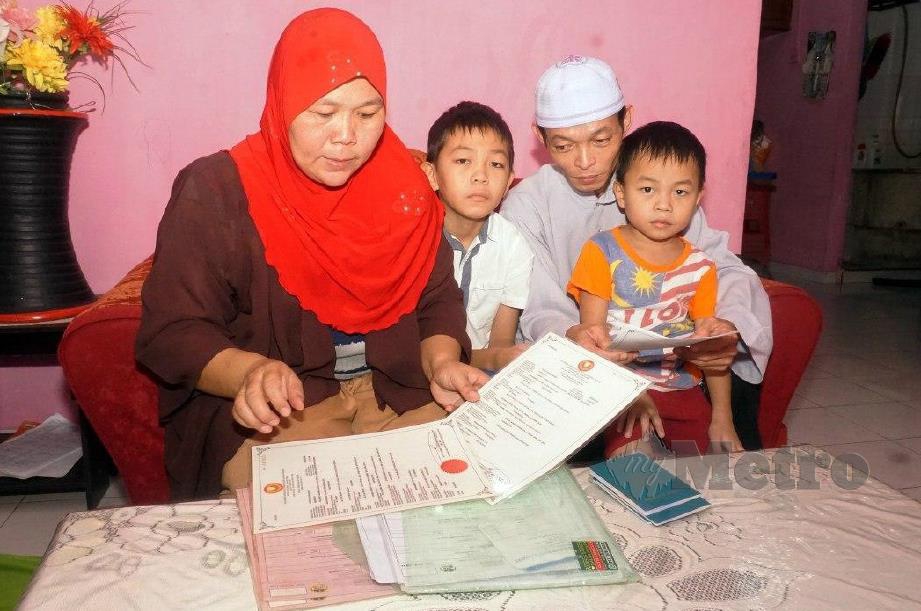 MUHAMMAD Adam Lai bersama isteri dan anak-anaknya melihat dokumen bagi pendaftaran sekolah selepas PKP. FOTO Noorazura Abdul Rahman