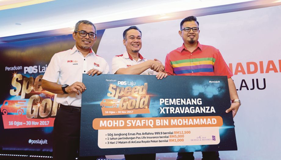 AZLAN  (tengah) menyampaikan hadiah kepada pemenang Xtravaganza, Mohd Syafiq Mohammad (kanan)  pada Majlis Penyampaian Hadiah Peraduan Pos Laju Speed Gold di Pos Malaysia Kompleks Dayabumi. 