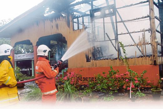 ANGGOTA bomba memadam kebakaran rumah mangsa. 
