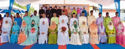 SERAMAI 13 pasangan pengantin bergambar kenangan selepas selesai majlis akad nikah di pentas utama kawasan parkir Masjid Jamek Bandar Kota Tinggi.