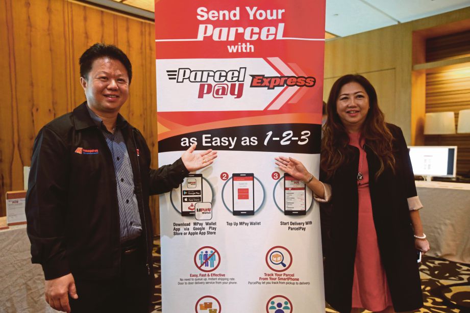 CHEW   (kiri) bersama Pengurus Besar ManagePay System, Janette Lim menunjukkan bunting pelancaran ParcelPay perkhidmatan terbaru dalam MPay di majlis pelancaran, semalam. 