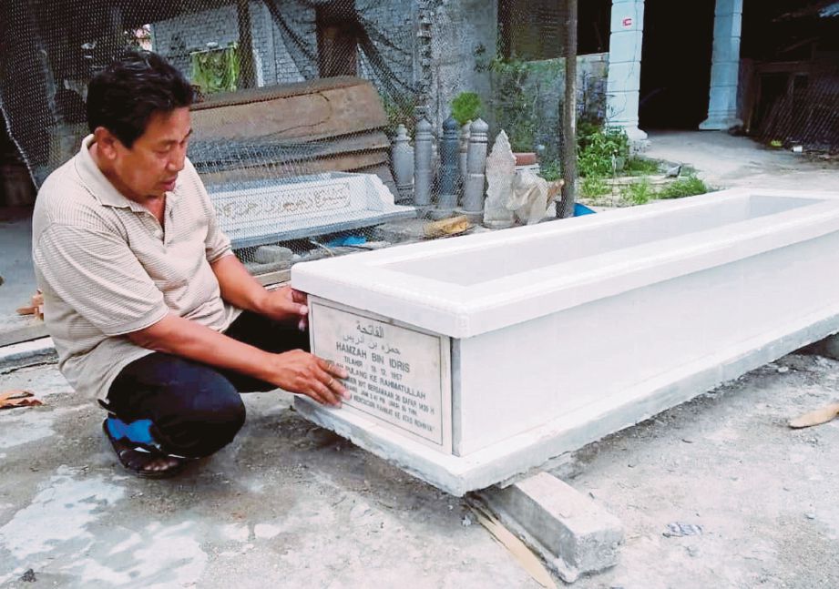 Wan Jonee memasang nama jenazah pada belindan yang diusahakannya.