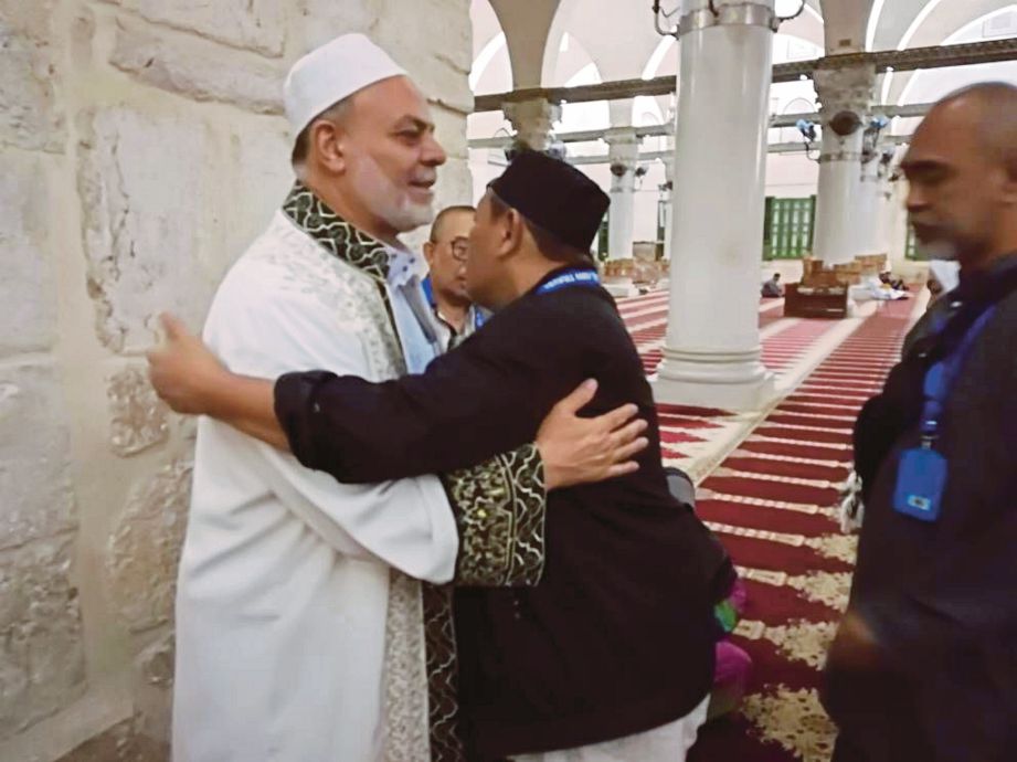 IMAM Masjid al-Aqsa Masjid al-Aqsa Syeikh Yusuf Abu Sneinah (kiri) memeluk jemaah Malaysia.